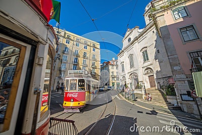 Very touristic place in the old part of Lisbon, with a traditional tram passing by in the city of Lisbon, Portugal. Editorial Stock Photo